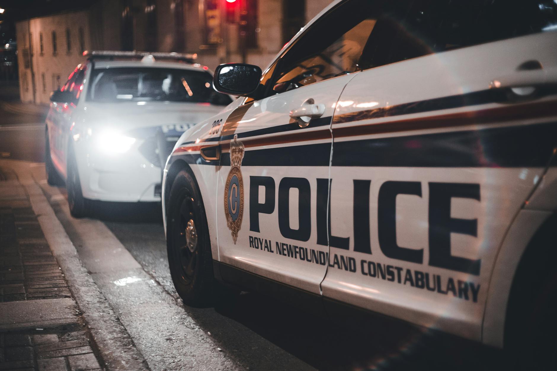 Close-up of Royal Newfoundland Constabulary police cars parked on a street at night.