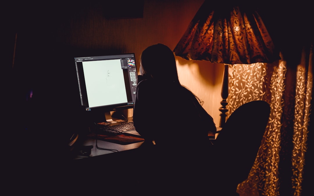 woman in black long sleeve shirt sitting on chair in front of computer