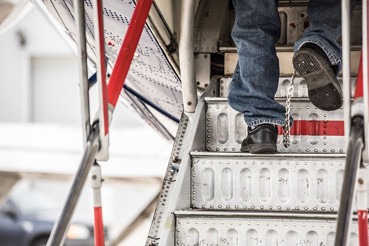 An illegal alien board a plane for a removal flight.