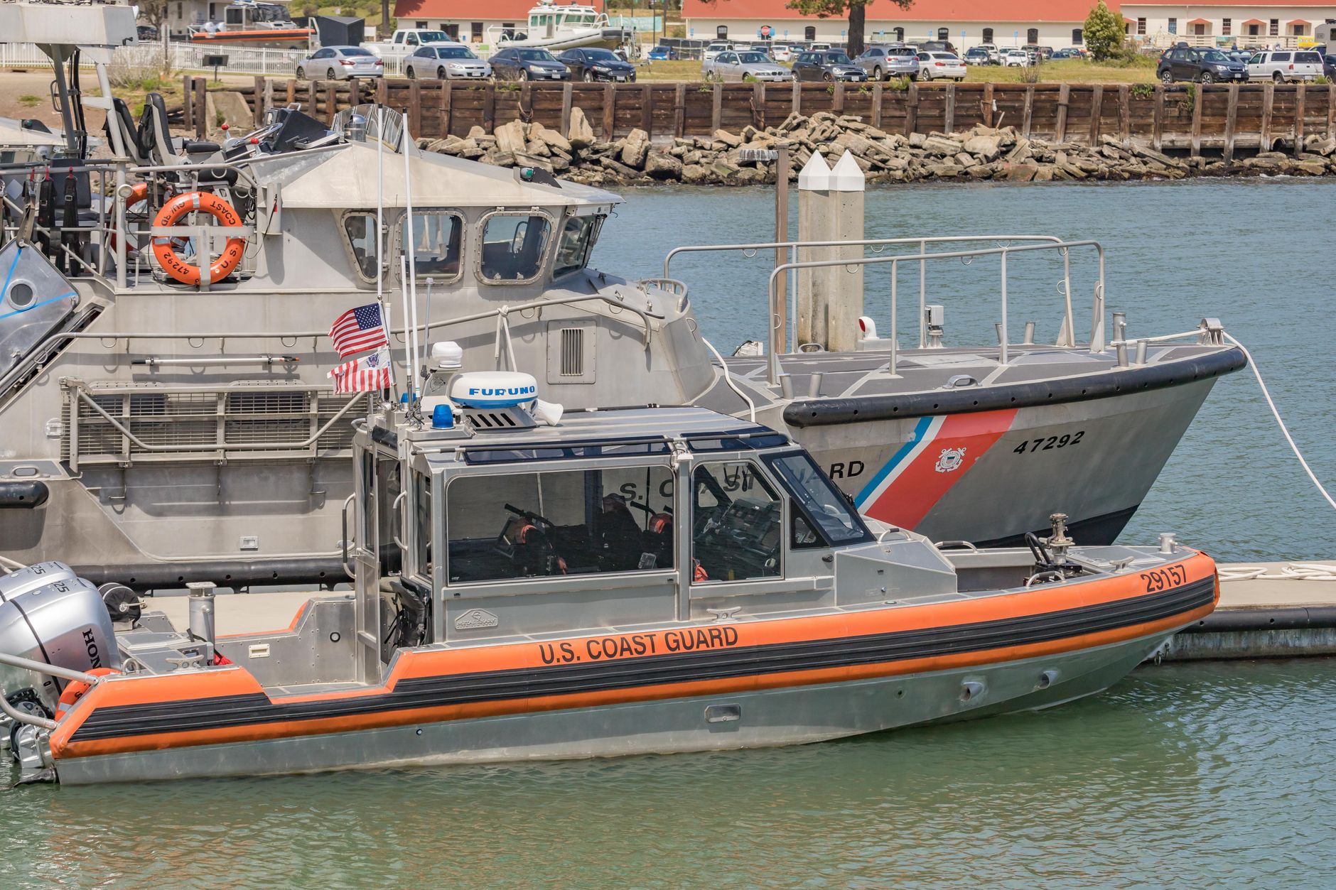 Two U.S. Coast Guard boats docked at a harbor, ready for action.